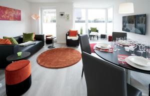 a living room with a dining table and a living room with a couch at MeerVerliebt C in Hörnum