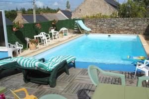 een groot zwembad met stoelen en een tafel bij Le Goéland in Sarzeau