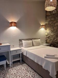 a bedroom with a bed and a desk and lights at Selin Hotel in Alacati