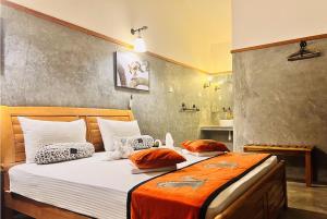 a bedroom with a large bed with an orange blanket at Yala Leopard Lodge in Yala