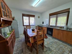 a kitchen with a table and a kitchen with a refrigerator at 801A Casa de 4 dormitorios en plena naturaleza in Muñás