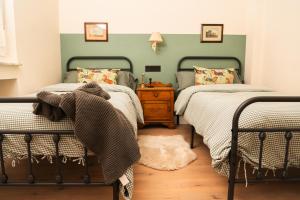 1 dormitorio con 2 camas individuales y suelo de madera en Casa Wenceslao, en Pola de Laviana