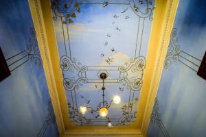 d'un plafond orné d'un lustre et d'oiseaux. dans l'établissement Marta Guest House, à Santa Maria del Giudice