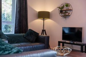 a living room with a couch and a television at Tobermory Apartment in Oban