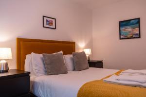 a bedroom with a bed with white sheets and pillows at Tobermory Apartment in Oban