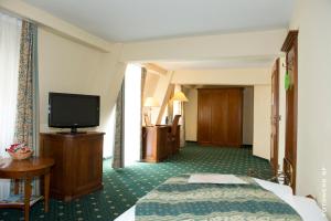 a hotel room with a bed and a flat screen tv at Hotel Schloss Schkopau in Schkopau