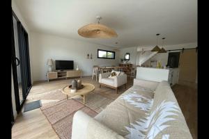 ein Wohnzimmer mit einem Sofa und einem Tisch in der Unterkunft St Malo à 15 Min et 10 Min de Dinard in Pleurtuit