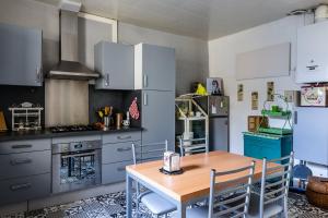 a kitchen with white cabinets and a wooden table at Le Vintage in Périgueux