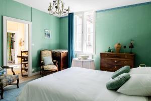 a bedroom with green walls and a bed and a chair at Le Vintage in Périgueux