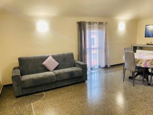 a couch with a pink pillow sitting in a living room at Casa Vacanze Libarna Outlet in Serravalle Scrivia