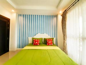 a bedroom with a green bed with two red pillows at Rocky Party Pool Villa Huahin 3 Bedrooom With BBQ & Karaoke in Hua Hin