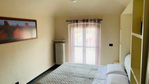 a bedroom with a bed and a window at Casa Vacanze Libarna Outlet in Serravalle Scrivia
