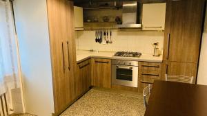 a kitchen with wooden cabinets and a stove top oven at Casa Vacanze Libarna Outlet in Serravalle Scrivia