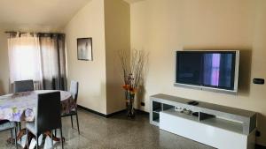 a living room with a television and a table with chairs at Casa Vacanze Libarna Outlet in Serravalle Scrivia