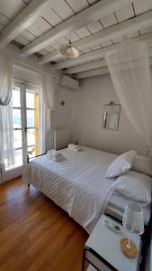 a bedroom with a large white bed and a window at Kamara in Kamares