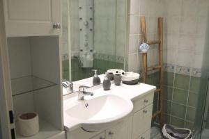 bagno con lavandino e specchio di Appartement avec piscine proche de la mer a La Londe-les-Maures