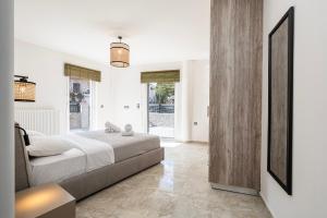 a bedroom with a large bed and a large window at Sea, Sand n' Style La Bella's Port & Beach Retreat in Kos