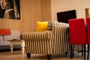 Sennecey-le-GrandにあるAuberg'Innのリビングルーム(ストライプのソファ、赤い椅子付)