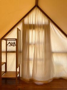una finestra in tenda con tenda bianca di BOHO GLAMPING CONIL a Cadice