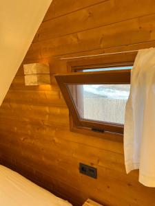 una camera da letto con finestra su una parete in legno di BOHO GLAMPING CONIL a Cadice