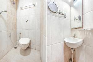 uma casa de banho com um WC, um lavatório e um espelho. em FabExpress Raj Supreme Residency em Chennai