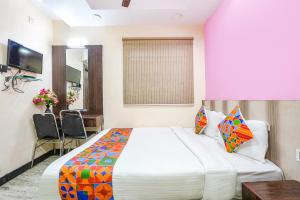 a hotel room with a large bed and a desk at FabExpress Raj Supreme Residency in Chennai