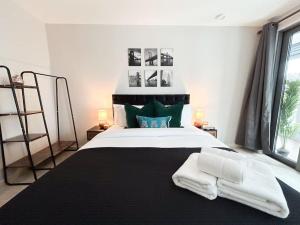 een slaapkamer met een groot bed en 2 handdoeken bij Stylish Urban Sanctuary with Parking in Londen
