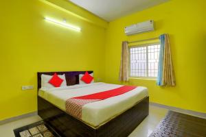 ein Schlafzimmer mit einem Bett mit gelben Wänden und einem Fenster in der Unterkunft OYO Flagship Dn Premium Villa in Jānla