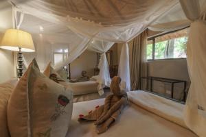 a bedroom with two beds with a canopy at Thamalakane River Lodge in Maun