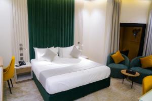 جلف ستار للشقق المخدومة GULF STAR APARTMENTs في الرياض: غرفه فندقيه بسرير وجدار اخضر