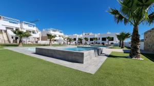 a swimming pool in a yard next to a building at Apartament Porto Marina in Torre de la Horadada