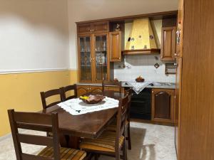 uma cozinha com uma mesa de madeira com cadeiras e um estofados de esteira em House Giulia al Borgo Marinaro em Avola