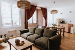 een woonkamer met een bank en een tafel bij Maison Hubert B&B in Bordeaux