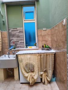 uma casa de banho com um lavatório, uma janela e um WC. em House Giulia al Borgo Marinaro em Avola