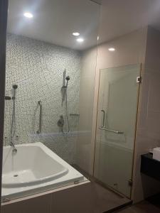 a bathroom with a shower and a tub and a sink at ไวท์ แซนด์ บีช เรสซิเดนซ์ พัทยา(White Sand Beach Residences Pattaya) in Na Jomtien