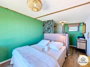 um quarto com uma cama branca e uma parede verde em Villa Bleu Camaïeu- 4 étoiles - avec piscine - Saint-Leu em Saint-Leu
