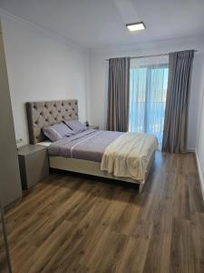 - une chambre avec un lit et une grande fenêtre dans l'établissement Cozy Apartments Avanera Suceava, à Suceava