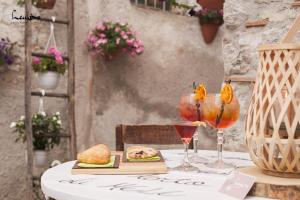 una mesa con dos copas de vino y un plato de comida en Leukòs Bed and Breakfast, en Castelsaraceno