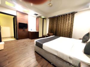 Habitación de hotel con cama y TV en Hotel Good Times Near Metro, en Nueva Delhi