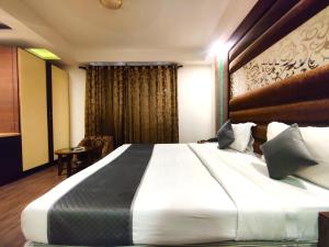 1 dormitorio con 1 cama blanca grande y ventana en Hotel Good Times Near Metro, en Nueva Delhi