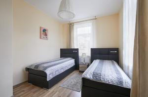 Un dormitorio con dos camas y una ventana. en Kauko Laiptu Apartment, en Kaunas