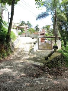Chácara Recanto das Pedras في جوارولوس: طريق ترابي يؤدي إلى منزل به أشجار