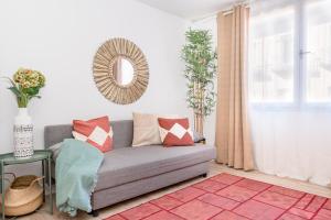 ein Wohnzimmer mit einer Couch und einem Spiegel in der Unterkunft Chueca I calle Farmacia 1BR 1BH in Madrid