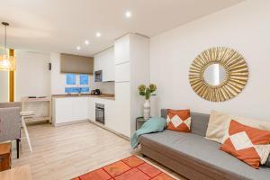 ein Wohnzimmer mit Couch und Küche in der Unterkunft Chueca I calle Farmacia 1BR 1BH in Madrid + 37 Fotos