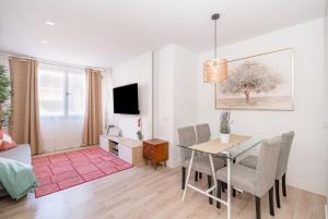 ein Wohnzimmer mit einem Esstisch und ein Wohnzimmer mit einem TV in der Unterkunft Chueca I calle Farmacia 1BR 1BH in Madrid