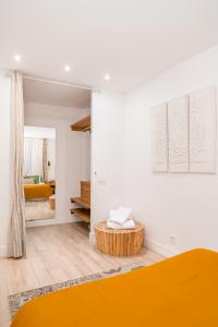 ein Schlafzimmer mit einem orangenen Bett und einem Spiegel in der Unterkunft Chueca I calle Farmacia 1BR 1BH in Madrid