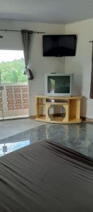 Chácara Recanto das Pedras في جوارولوس: غرفة معيشة مع تلفزيون بشاشة مسطحة على طاولة