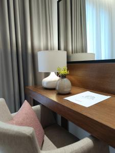 escritorio en una habitación de hotel con lámpara y sillas en Maison Hotel, en Halkidona