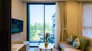 ein Wohnzimmer mit einem Sofa und einem Balkon in der Unterkunft Laguna Skypark апартаменты in Strand Bang Tao