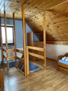 - une chambre avec lits superposés dans une maison en bois dans l'établissement Agroturystyka u Dudków, à Jeleśnia